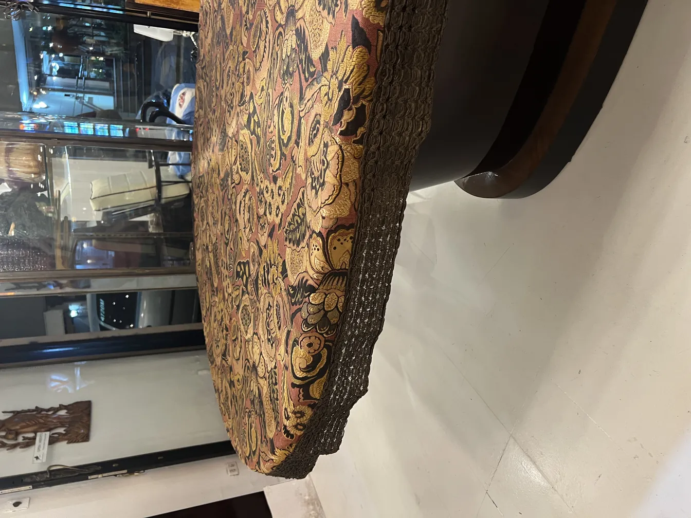 mantel antiguo con patrones florales en tonos cálidos, decorando una mesa