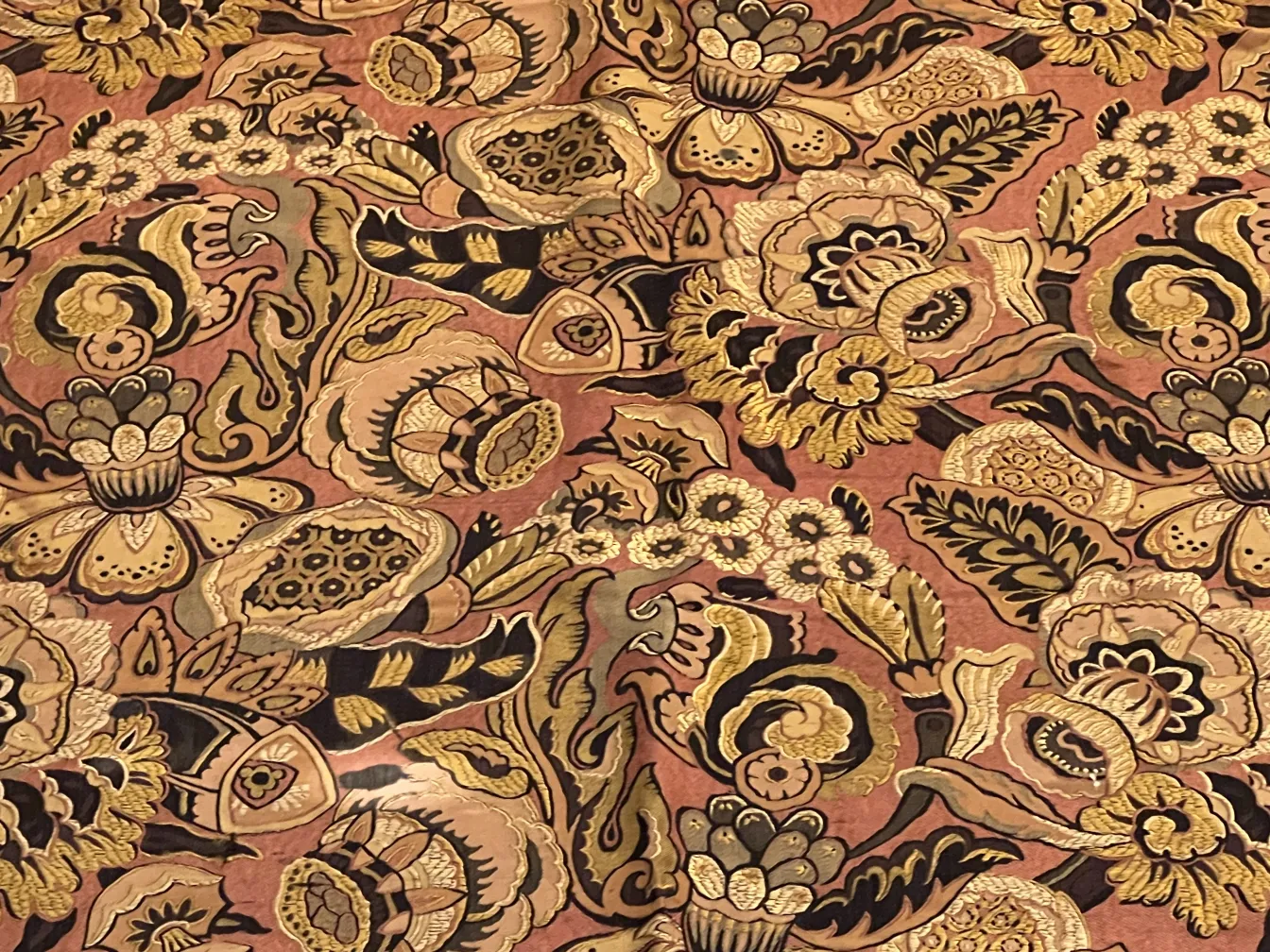 toalha de mesa antiga com desenhos florais coloridos sobre fundo claro