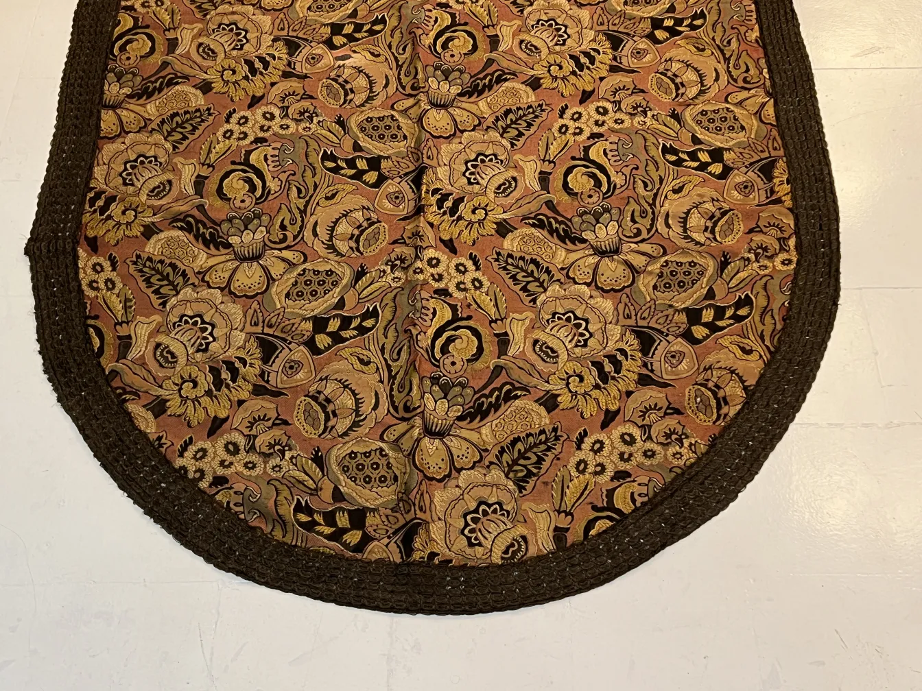 mantel antigüo con colorido diseño floral en tonos cálidos