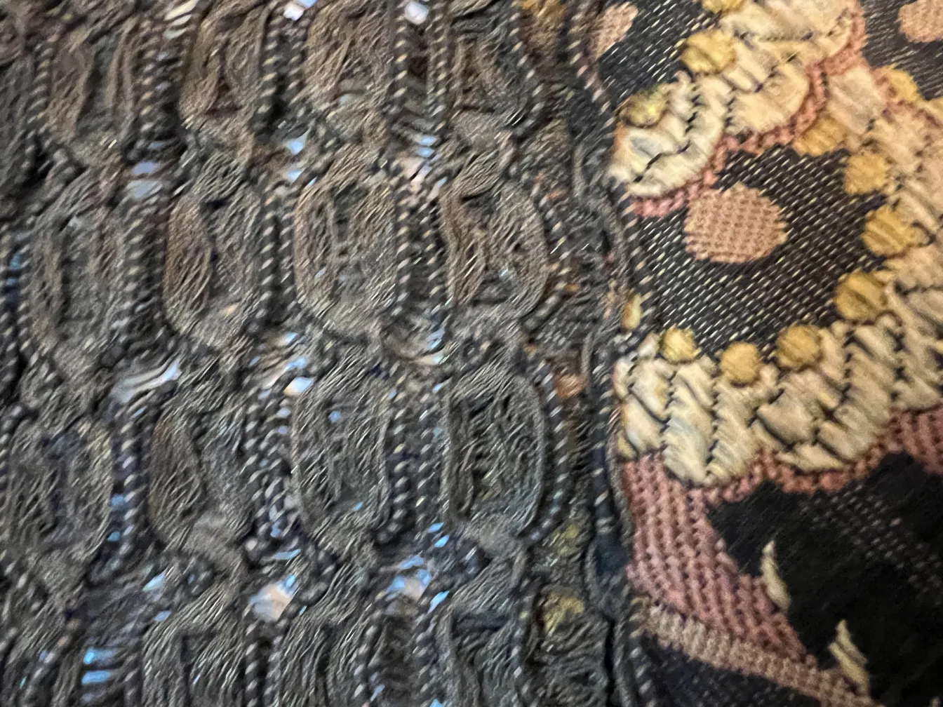 detail of antique tablecloth with dark patterned designs