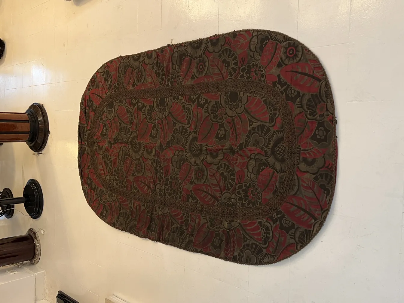 Mantel antiguo con diseño de flores rojas y verdes, en un ambiente clásico