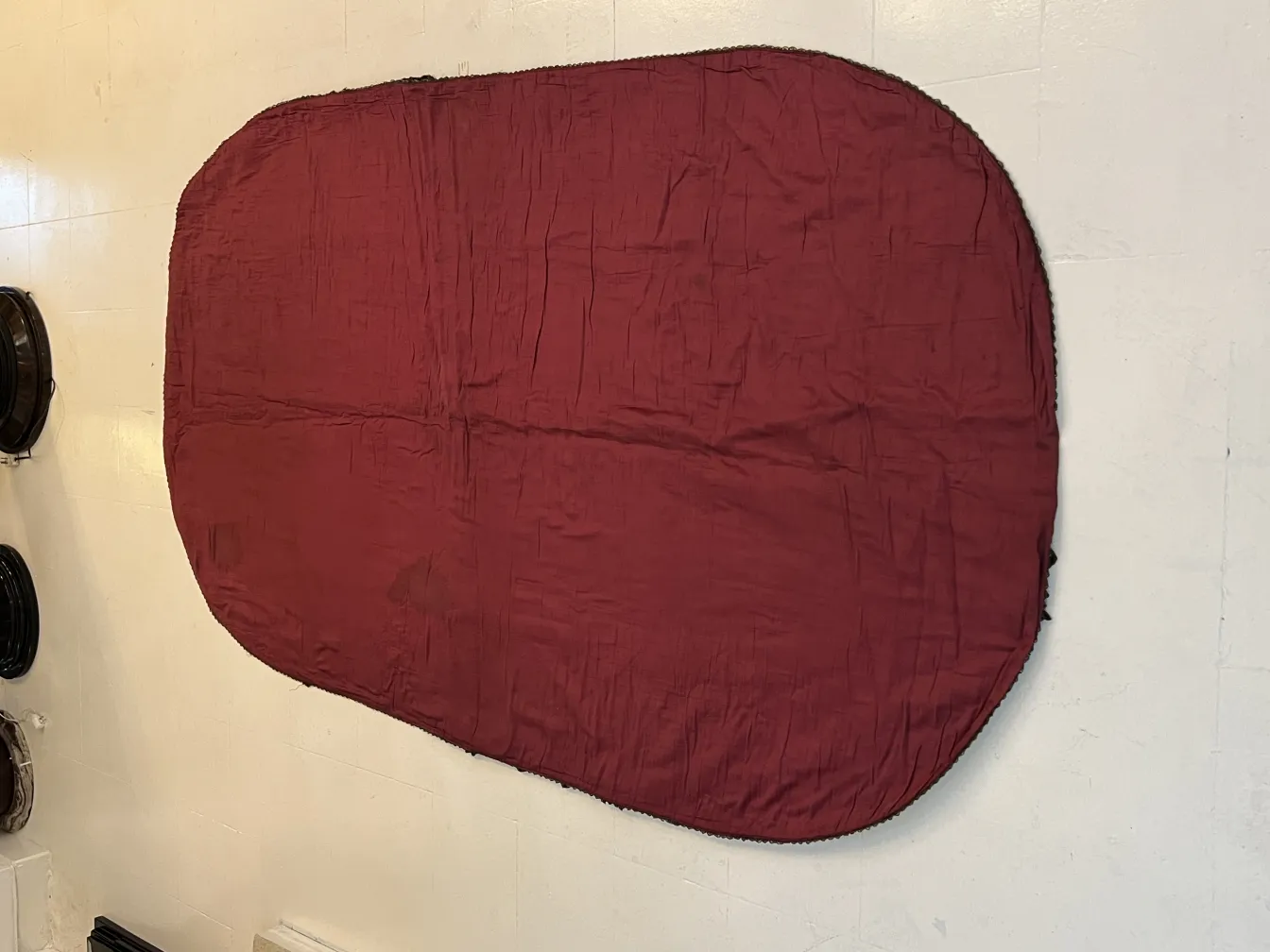nappe antique ovale de couleur bordeaux sur fond neutre