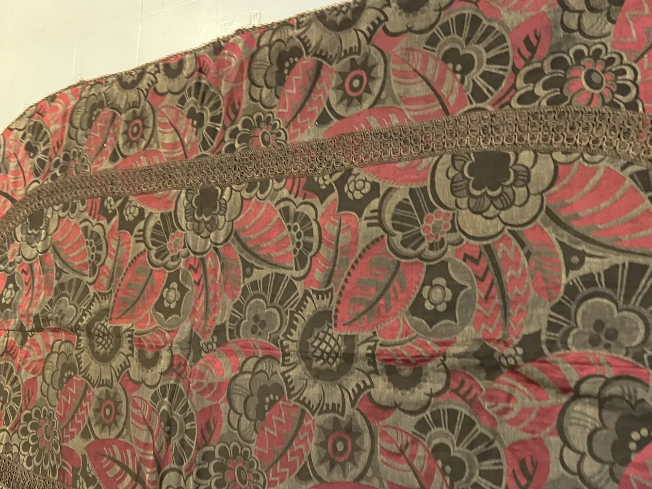 mantel antiguo con un diseño floral colorido en tonos de rosa y verde