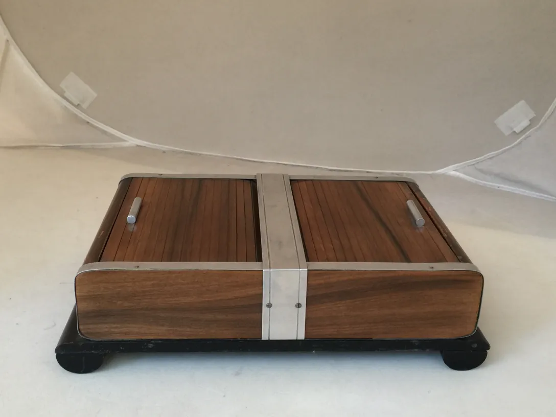 Caja antigua con compartimentos y tiradores, fondo claro.