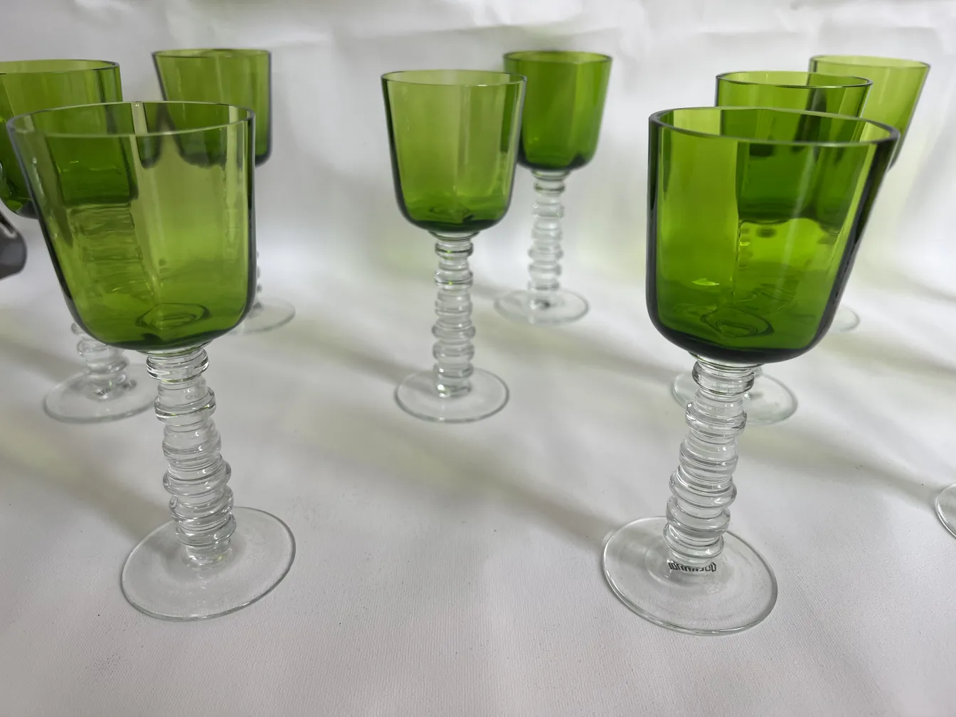 12 antique Querandi glasses with green and clear bases on white background