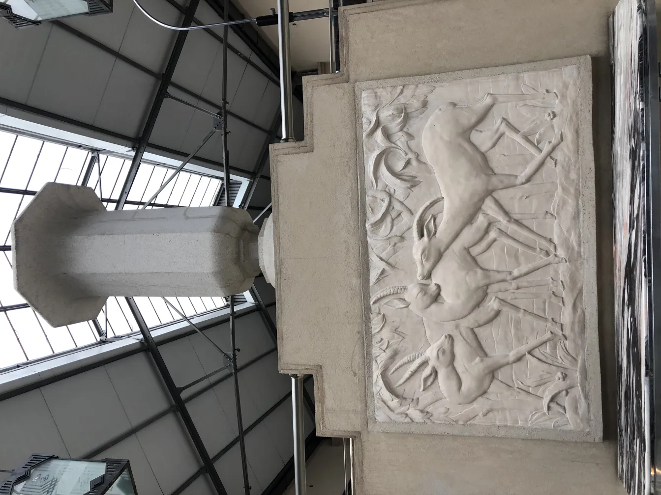 Calice decorativo antico con rilievo di cervi su fondo chiaro.