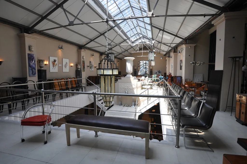 Copón decorativo antiguo en un ambiente elegante con sillas y arte