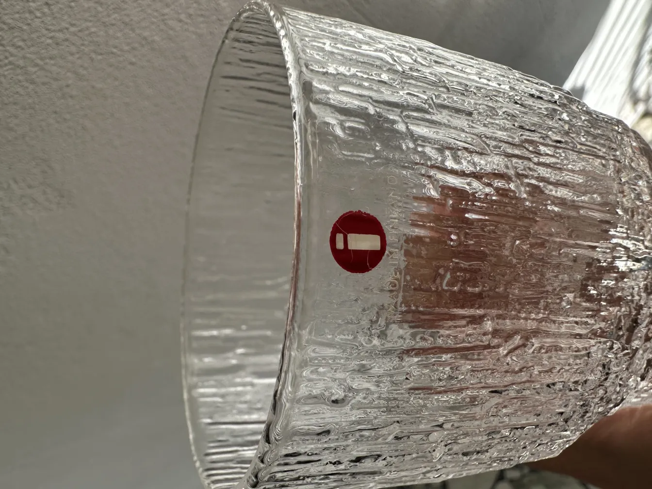 Eight tapio wirkkala glasses with clear texture in a bright setting.