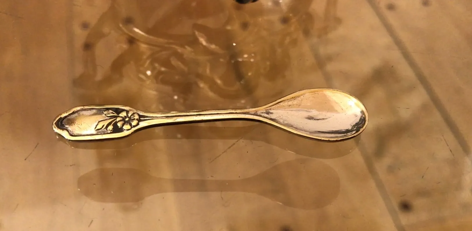 saleiro e pimenteiro antigo WMF com design floral, sobre uma mesa de madeira