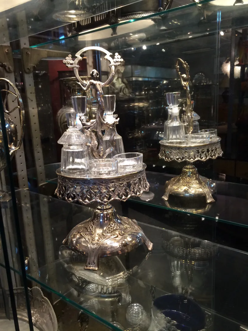 Ensemble antique de salière, poivrière, huile et vinaigre WMF sur une étagère.