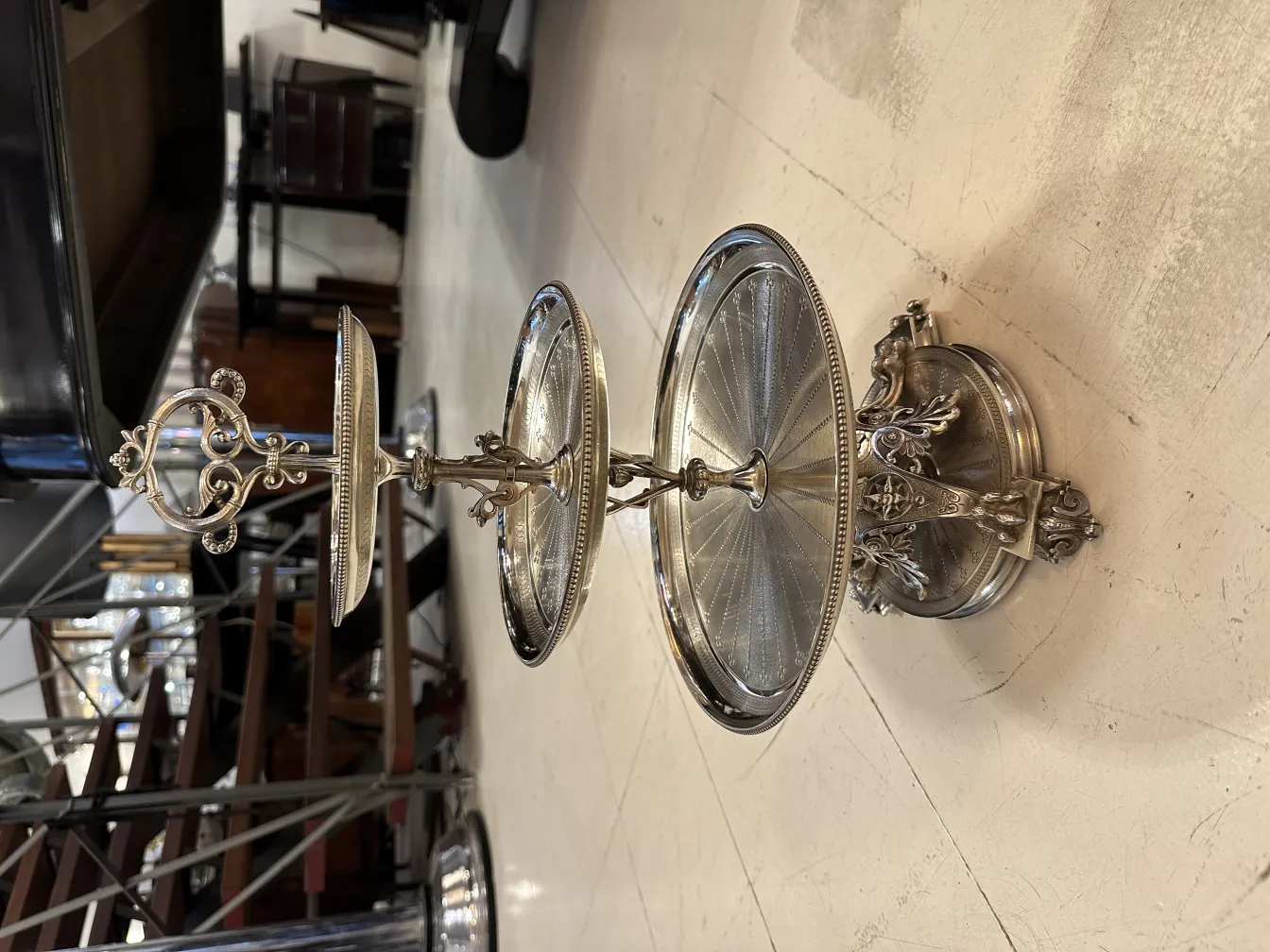 Piatto da dolci antico a due livelli con dettagli decorativi. Ambiente elegante.