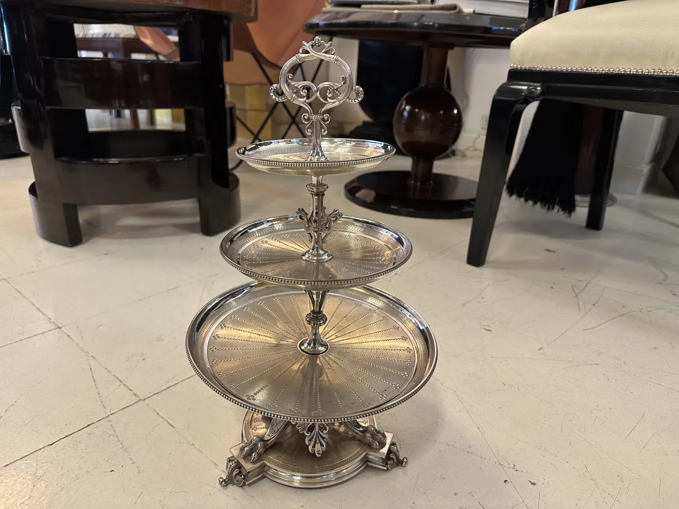 Piatto da dolci antico a tre livelli con dettagli decorativi, perfetto per dessert in un ambiente elegante.