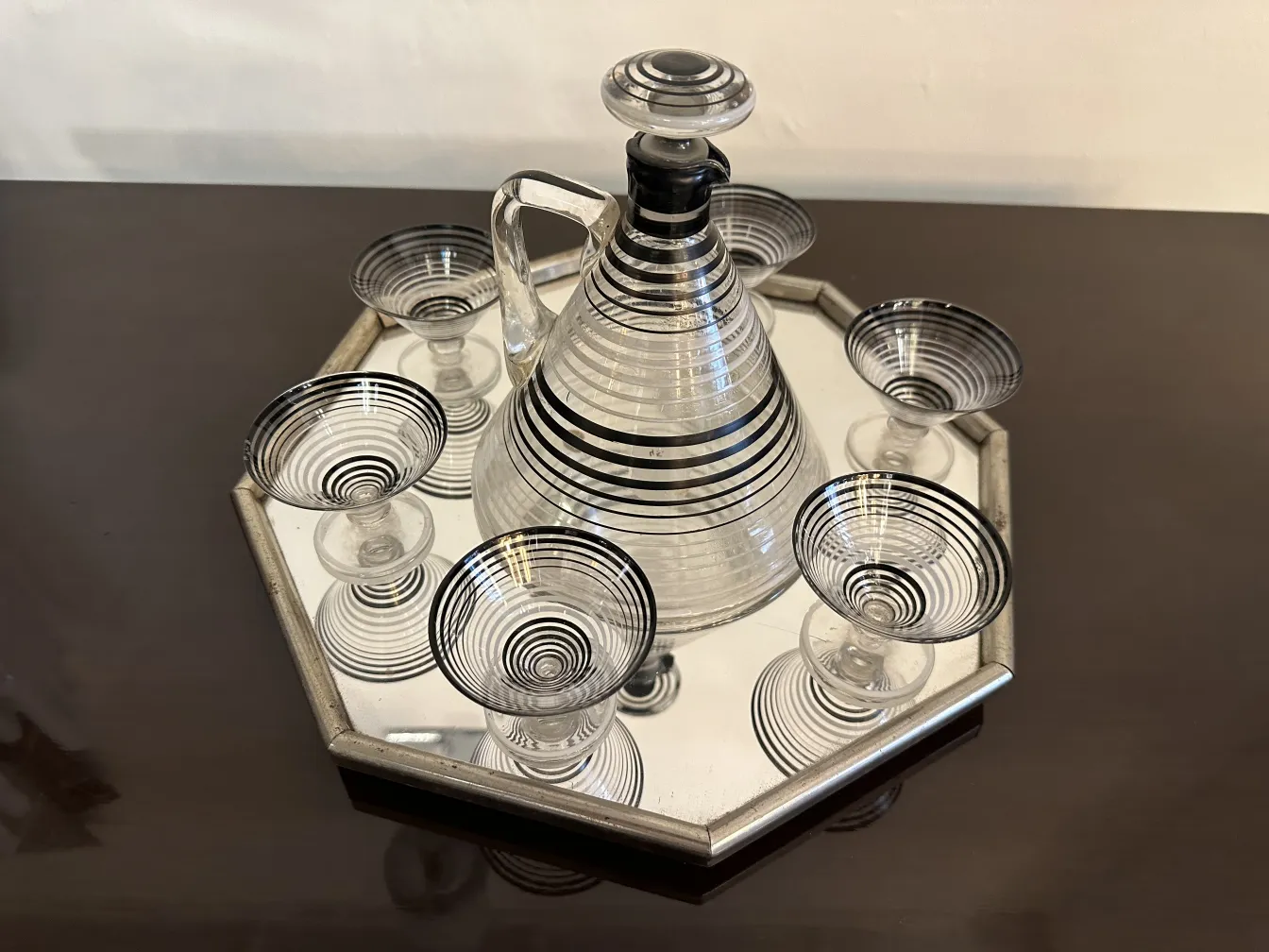 front view of an antique liqueur set with 6 striped glasses on a mirrored tray
