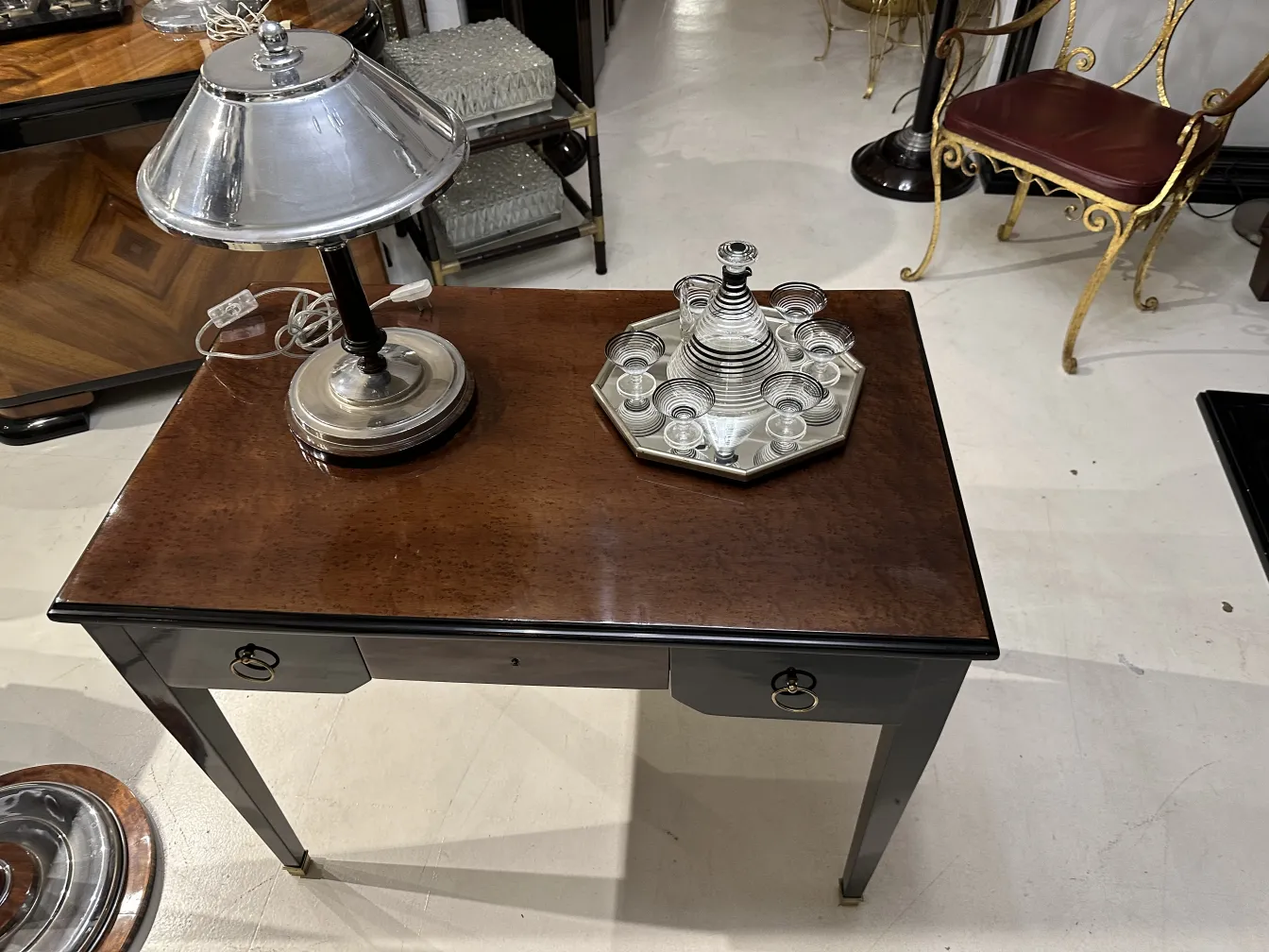 Set di liquore antico con 6 bicchieri decorativi su un tavolo elegante.