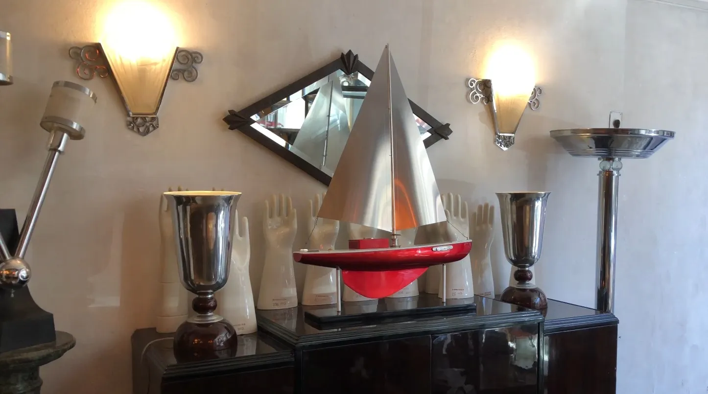 Barco do designer com velas prateadas e vermelhas em uma vitrine decorativa