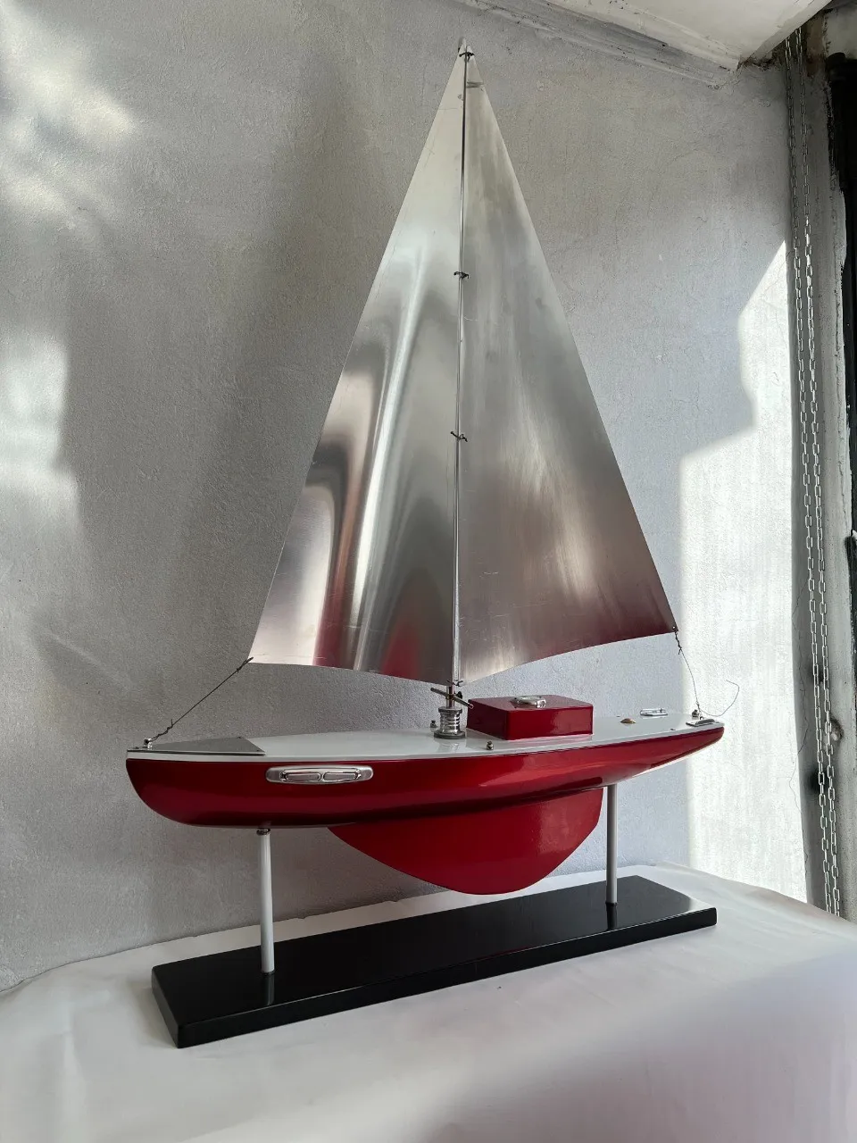 Model of an antique ship by the designer in red with sails