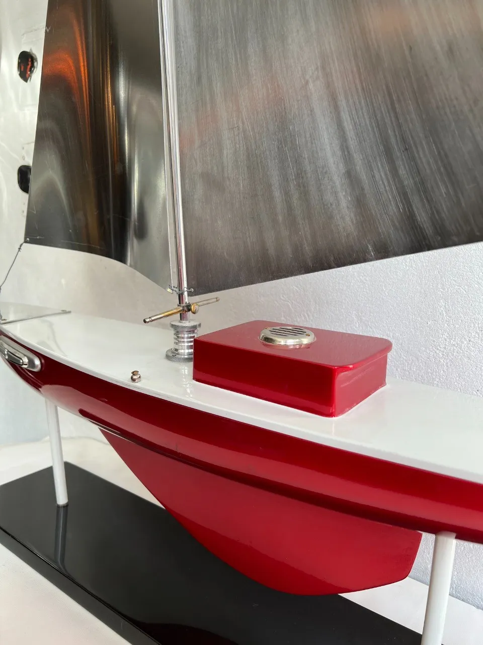 Bateau ancien du designer Marcelo Peña, avec voile argentée et base noire, détail exquis.