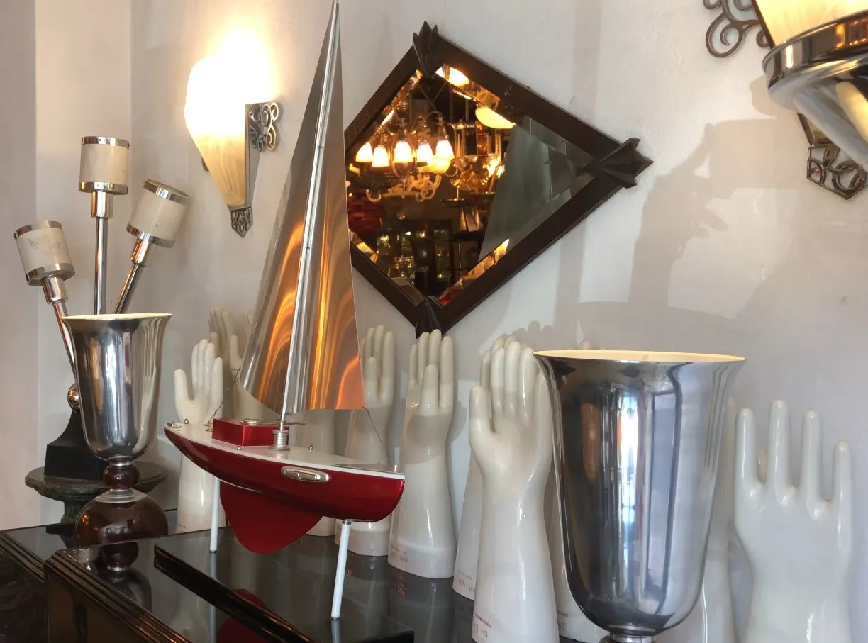 Antiguo barco del diseñador Marcelo Peña en un entorno decorativo con luces y objetos variados.