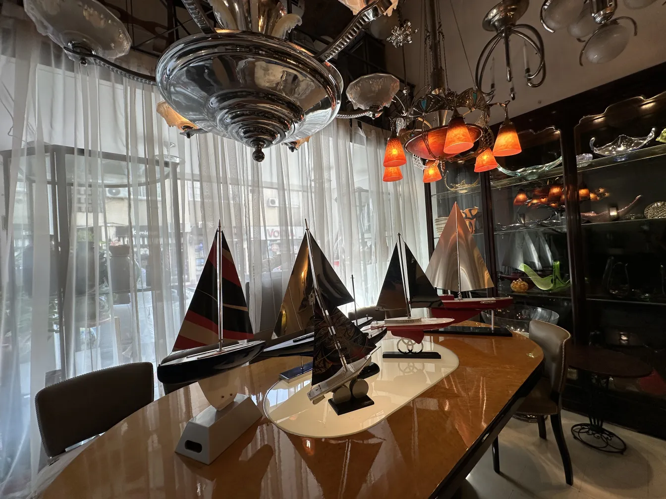 Modelo de barco antiguo del diseñador Marcelo Peña en sala luminosa con accesorios decorativos.