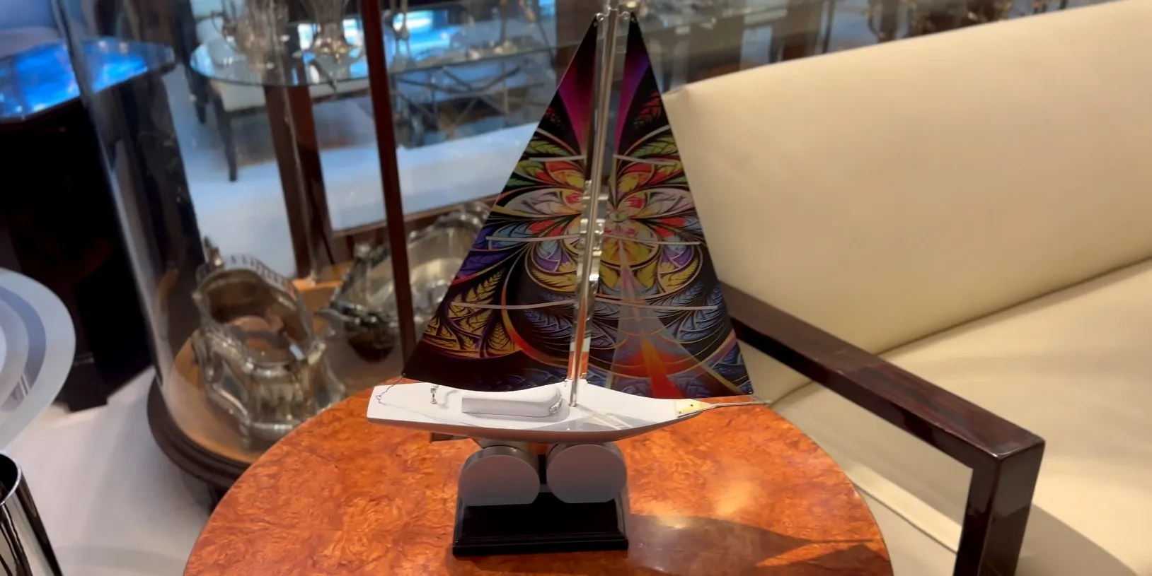 Antique designer's ship with colorful sail in an elegant setting.