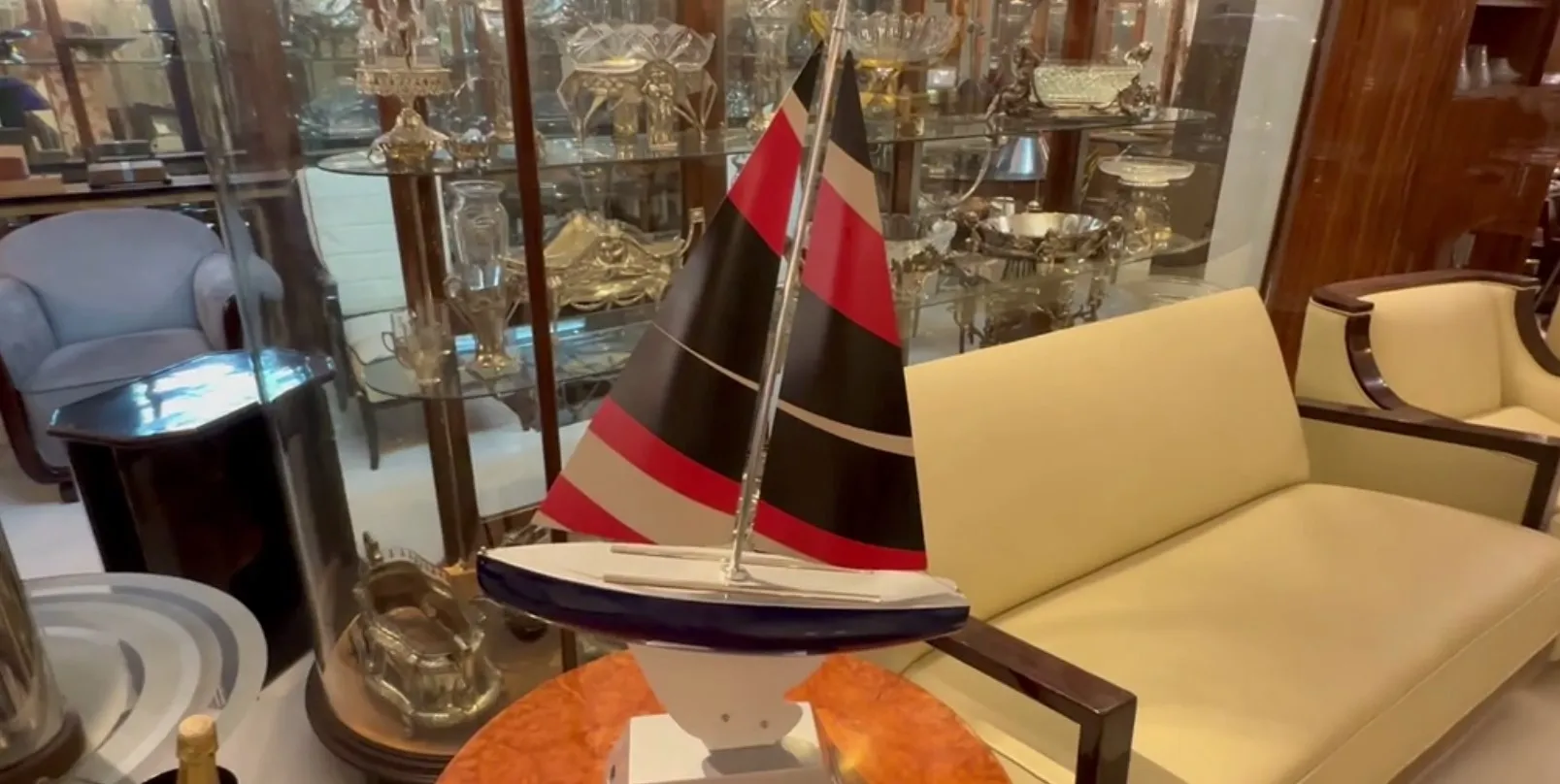 Bateau ancien du designer avec des voiles noires et rouges, dans un cadre élégant.