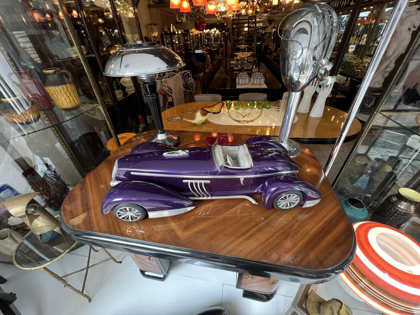 Antique designer car model, purple color, on table