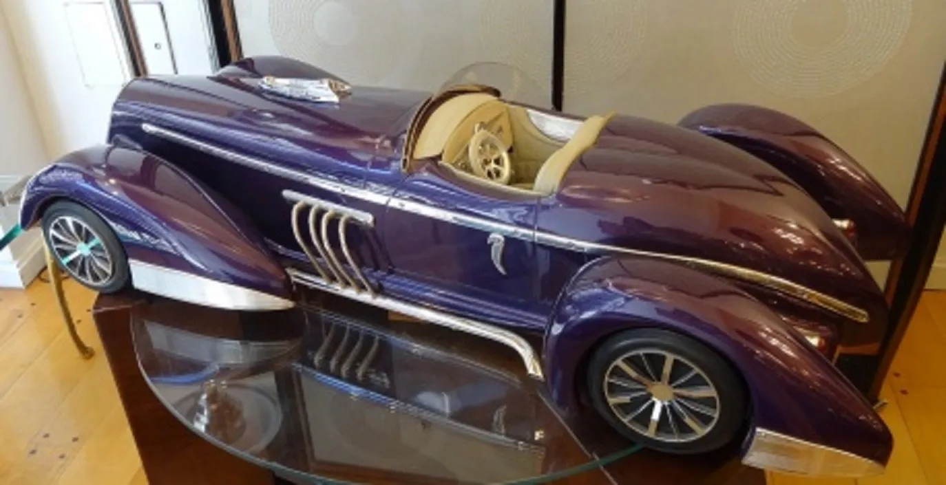 Auto antiguo del diseñador Marcelo Peña, color púrpura, elegante y curvado.