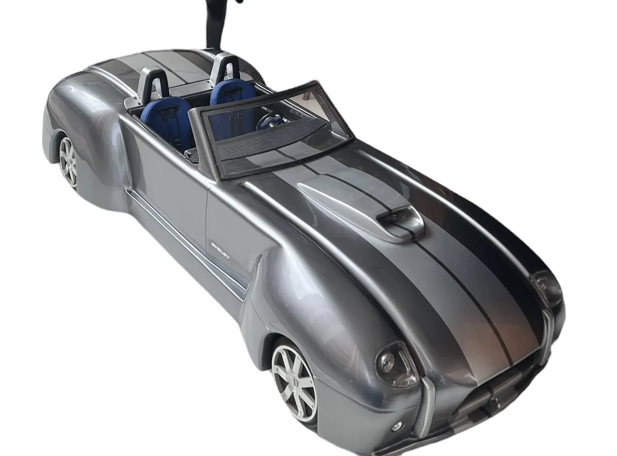 Voiture antique du designer Marcelo Peña, couleur argent, avec des détails élégants et des sièges bleus.