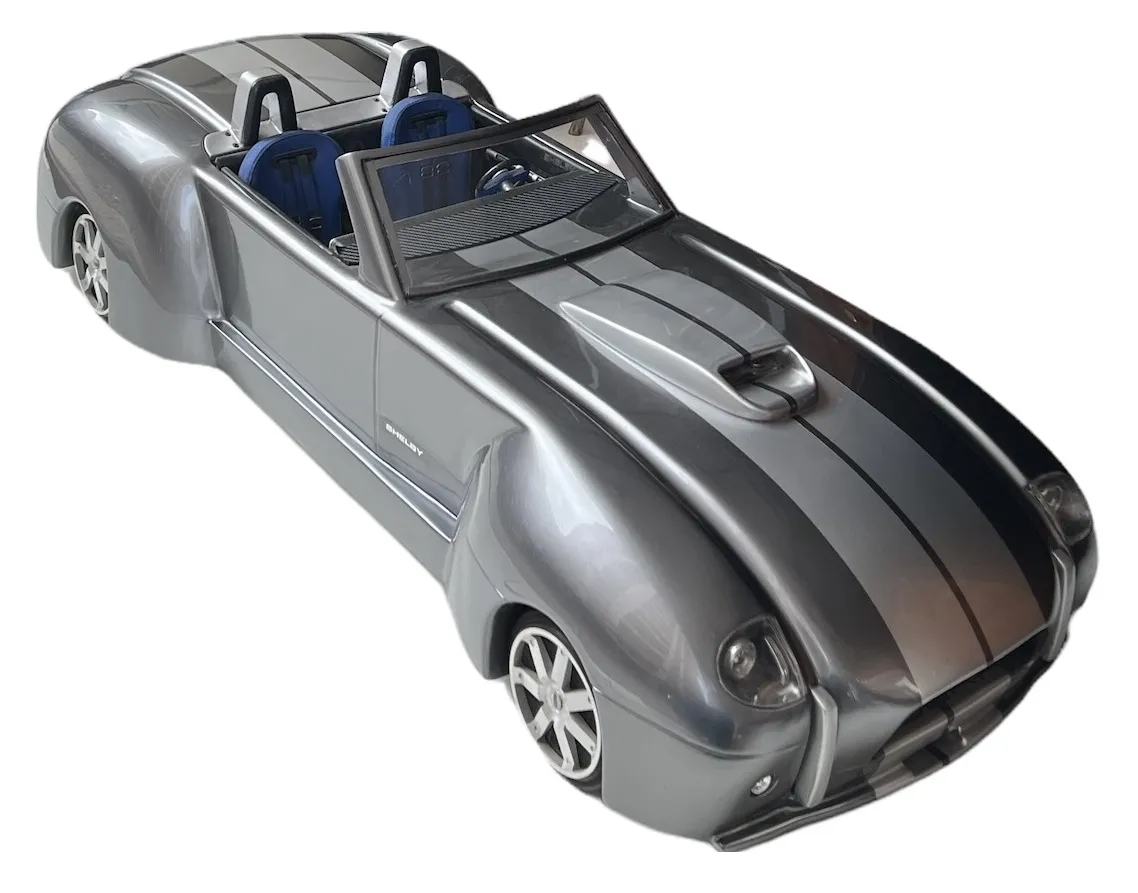 Voiture ancienne du designer Marcelo Peña, avec un design argenté accrocheur et intérieur bleu.