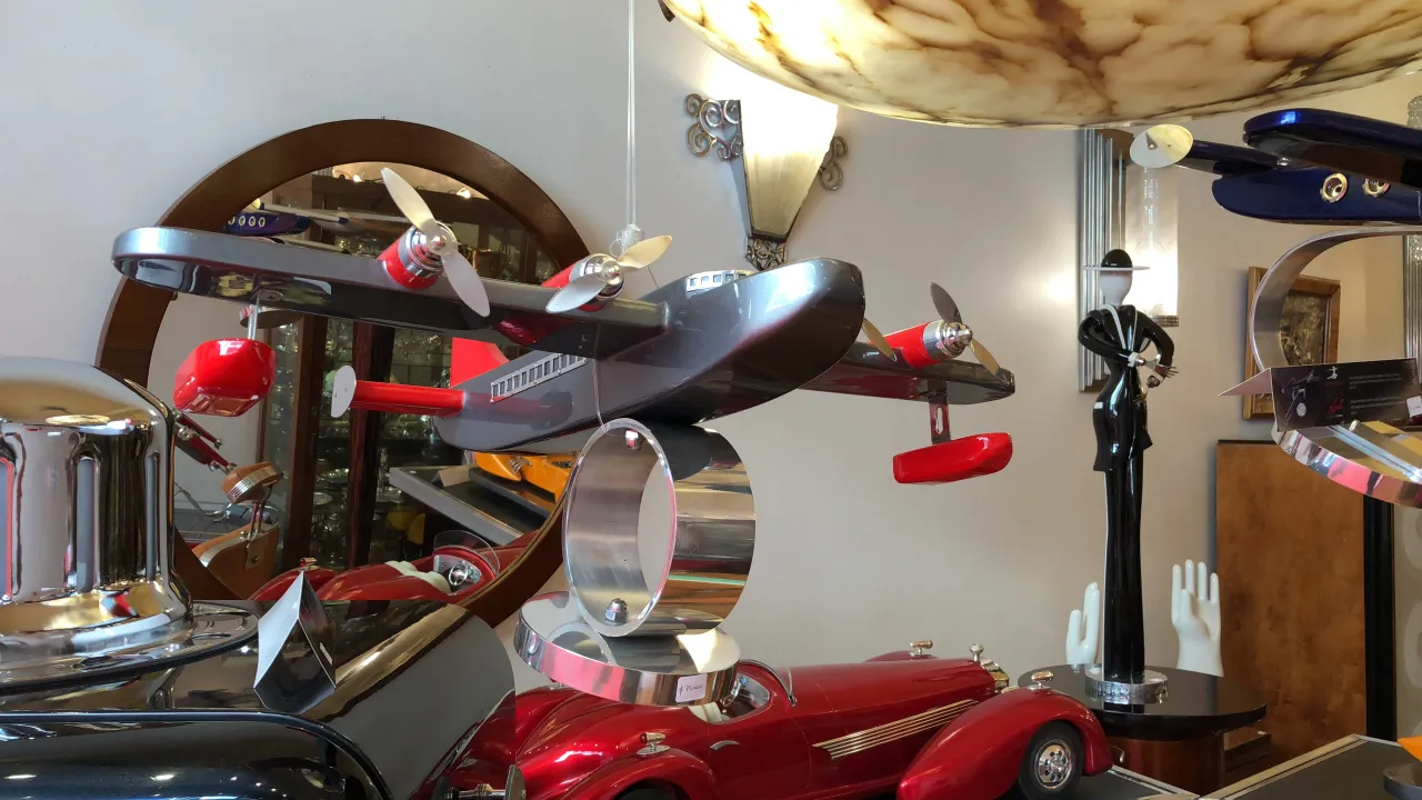 Modelo de aviões do designer Marcelo Peña com detalhes antigos, exposto em um ambiente elegante.