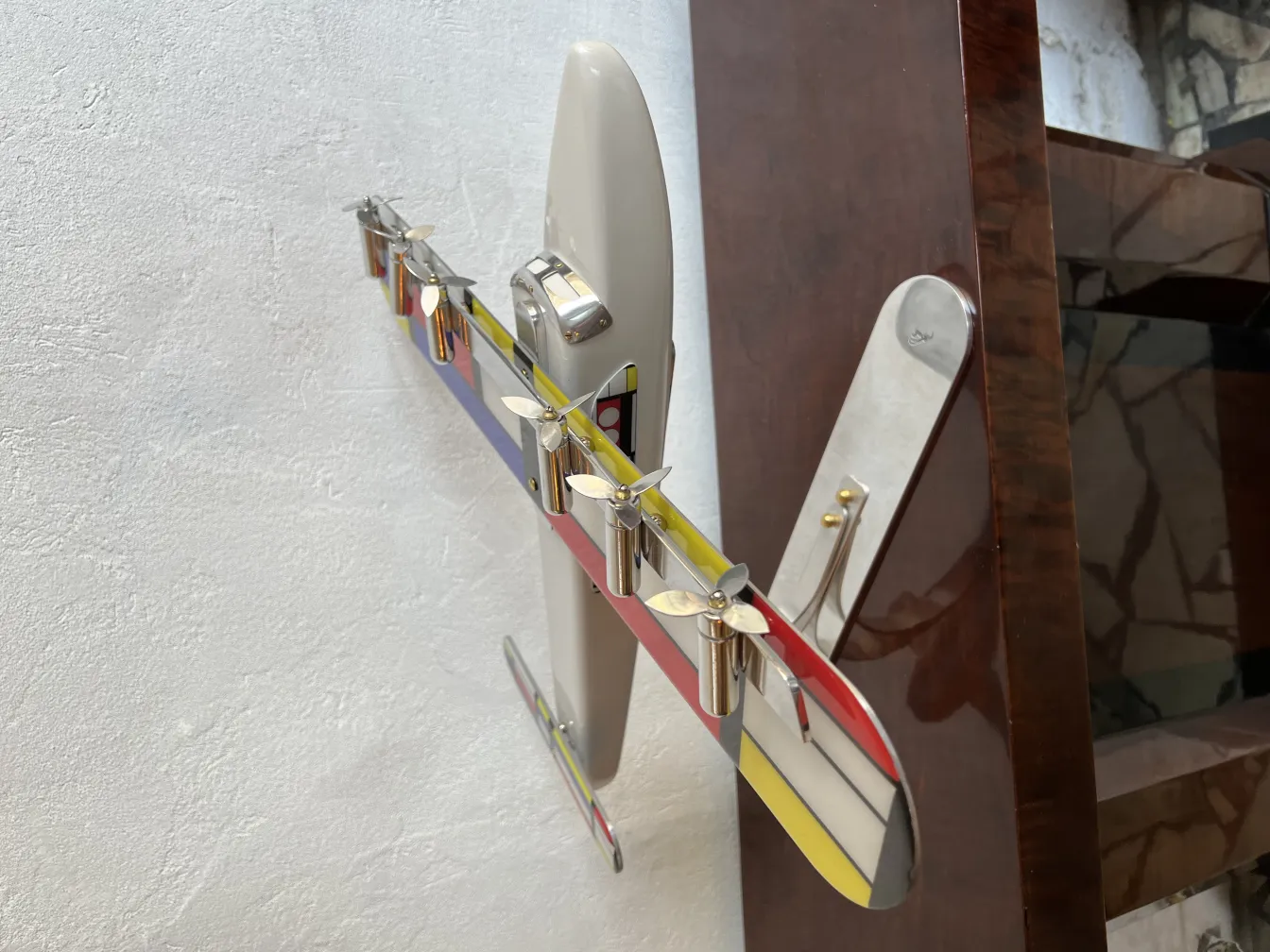 Buntes Flugzeugmodell des Designers Marcelo Peña vor weißem Hintergrund