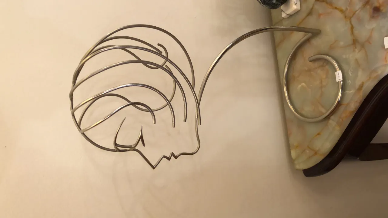 antique sculpture featuring a stylized face with flowing lines