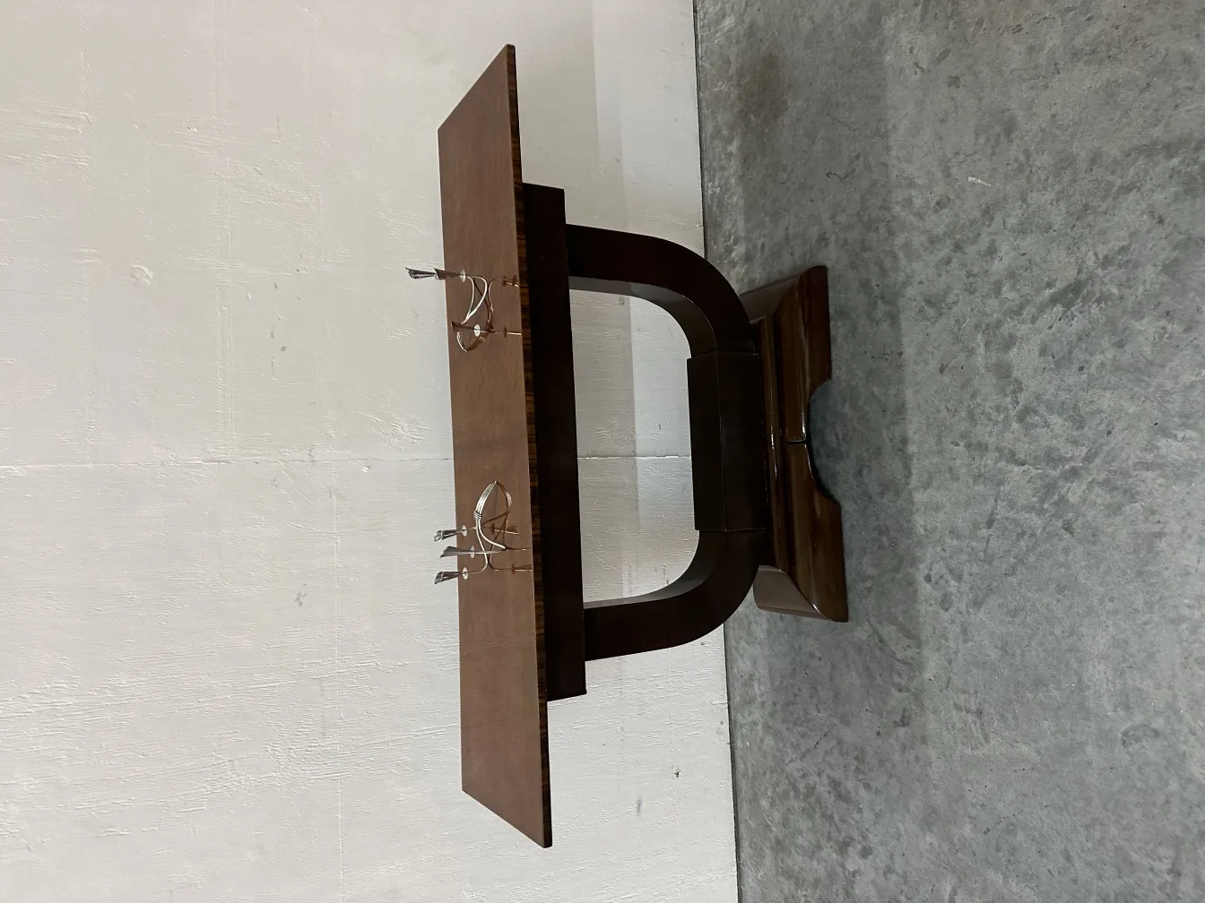 Antike Konsole mit dekorativem Design in dunklem Ton.