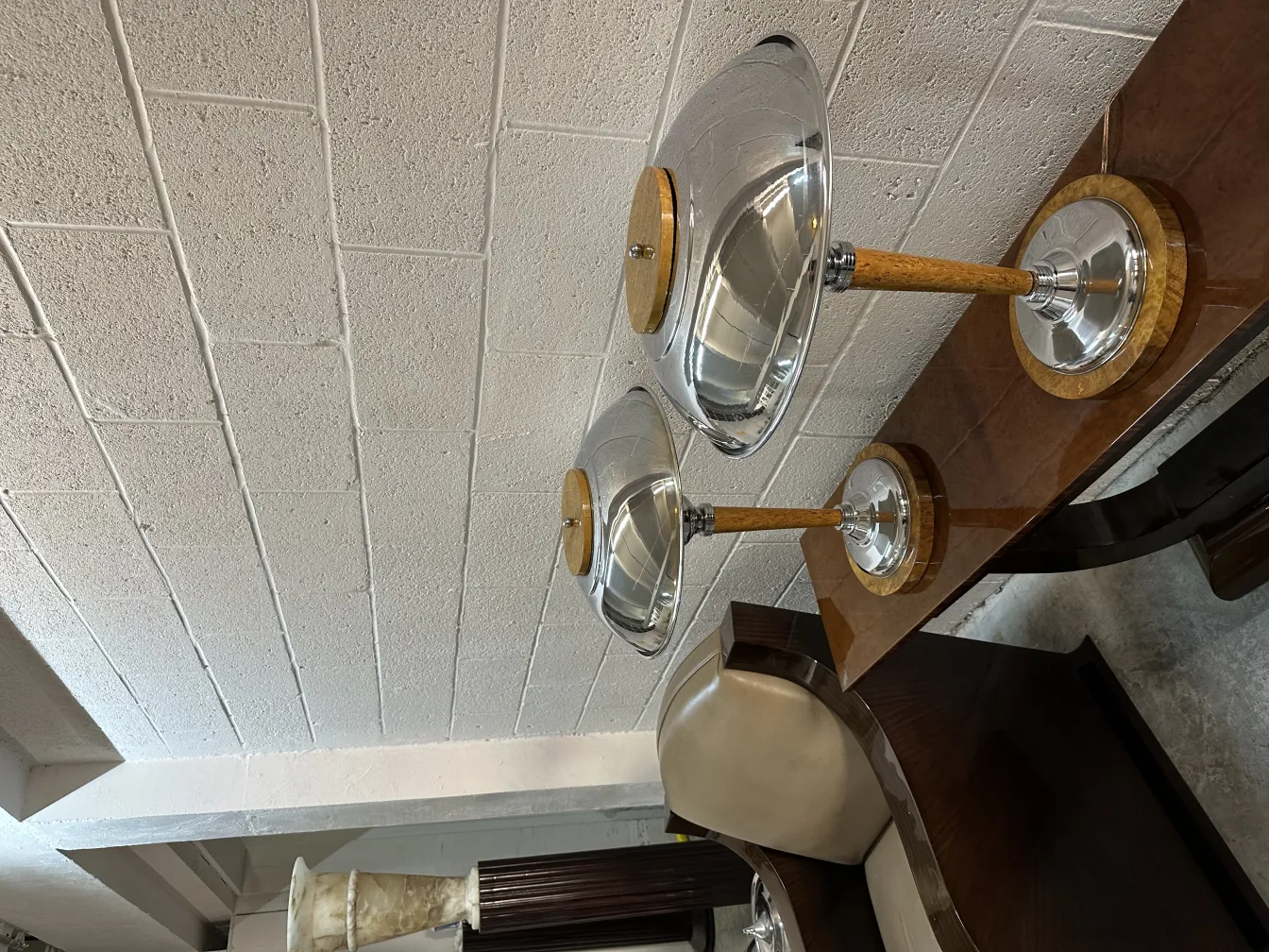 Antica consolle con lampade moderne in un ambiente decorativo.