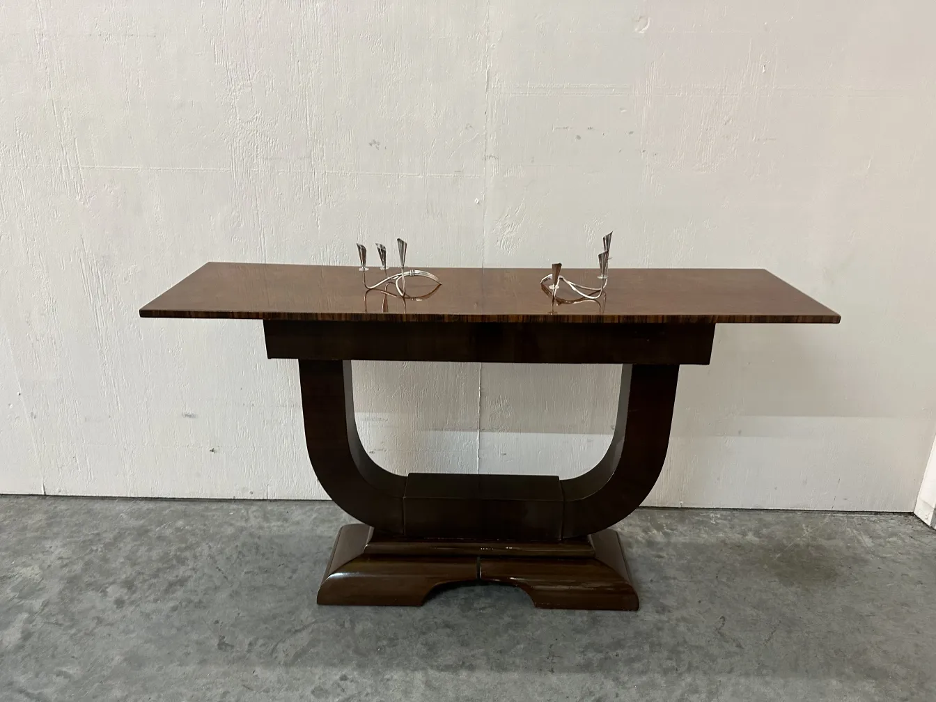 Mesa consola antiga com design elegante e acabamento liso, em um ambiente aconchegante.