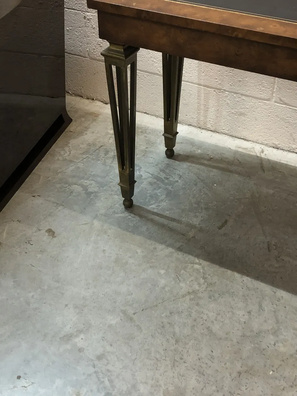 vista de una consola antigua con patas decorativas, en un ambiente sencillo