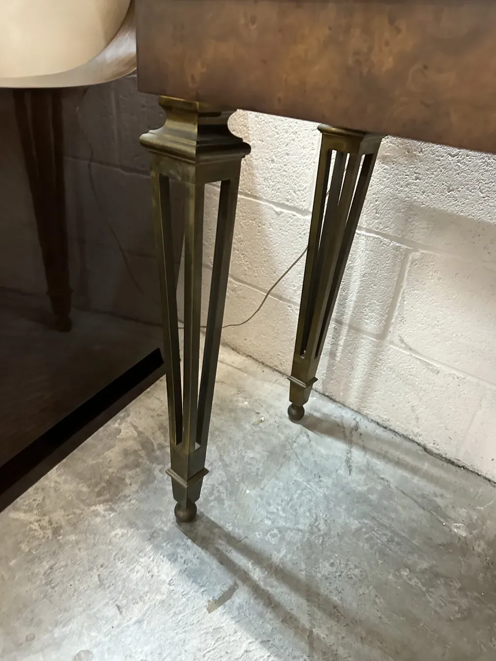 antica console con gambe decorative e sfondo chiaro