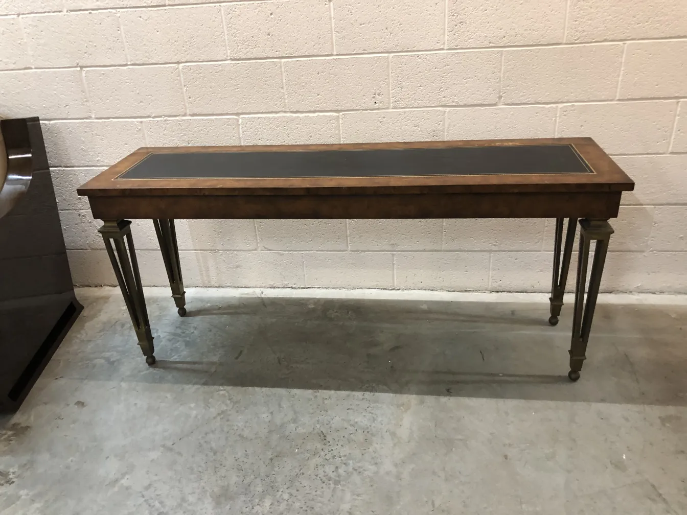 antigua consola con superficie oscura y patas doradas