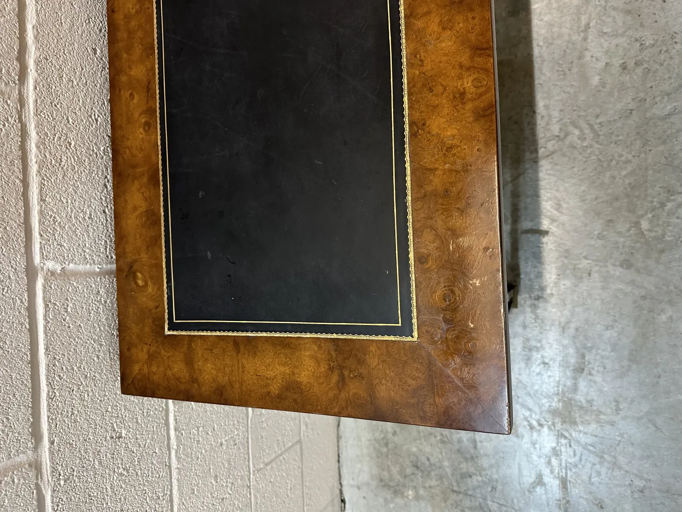 vue d'une console ancienne, avec une surface noire et des détails dorés