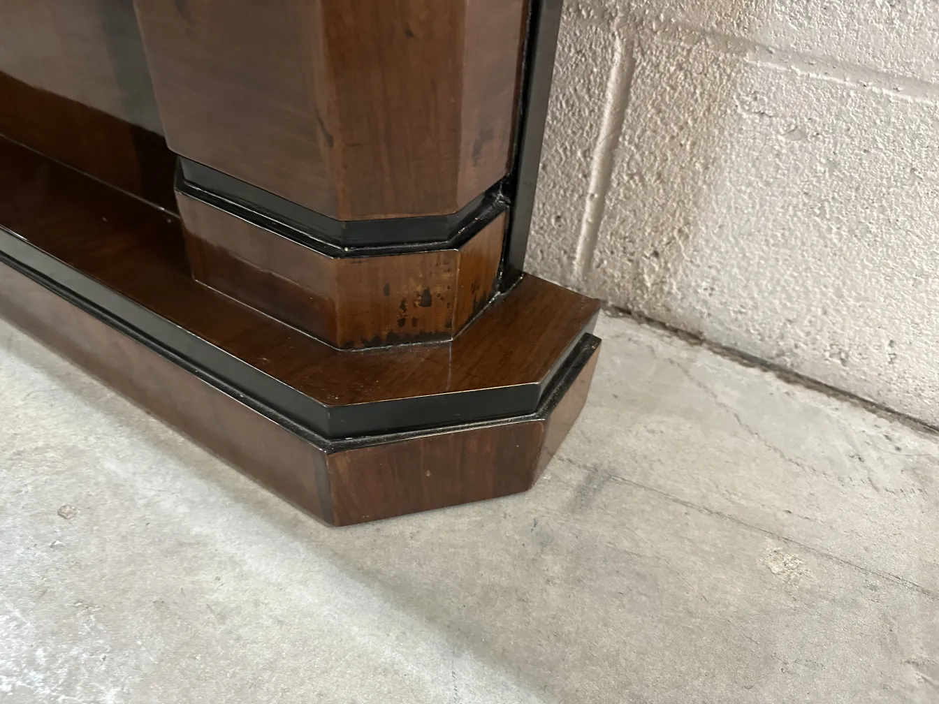 Imagem de antiguidades com 2 consoles elegantes em um ambiente simples.