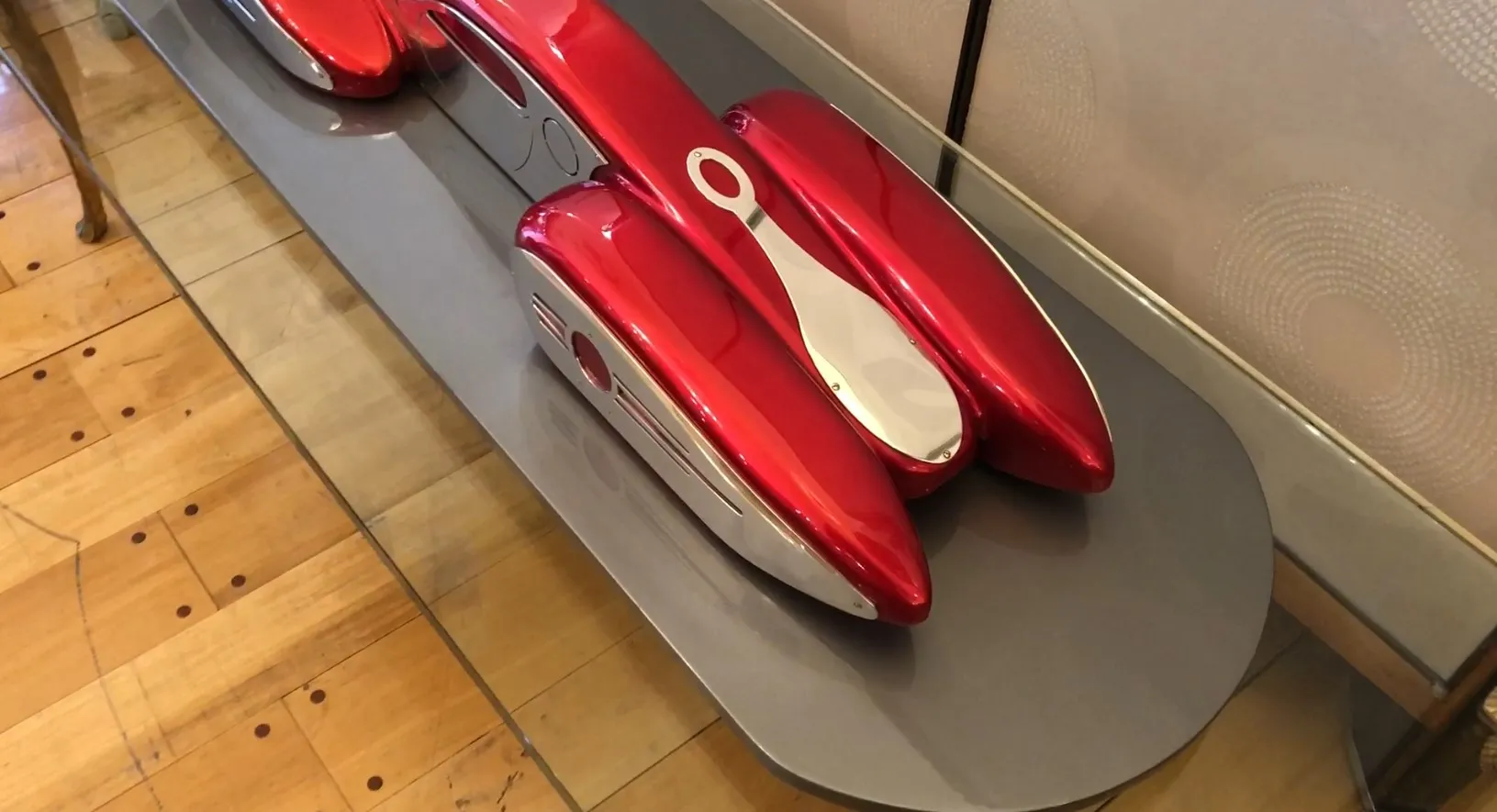 Voiture rouge brillant du designer Marcelo Peña exposée dans un cadre élégant.