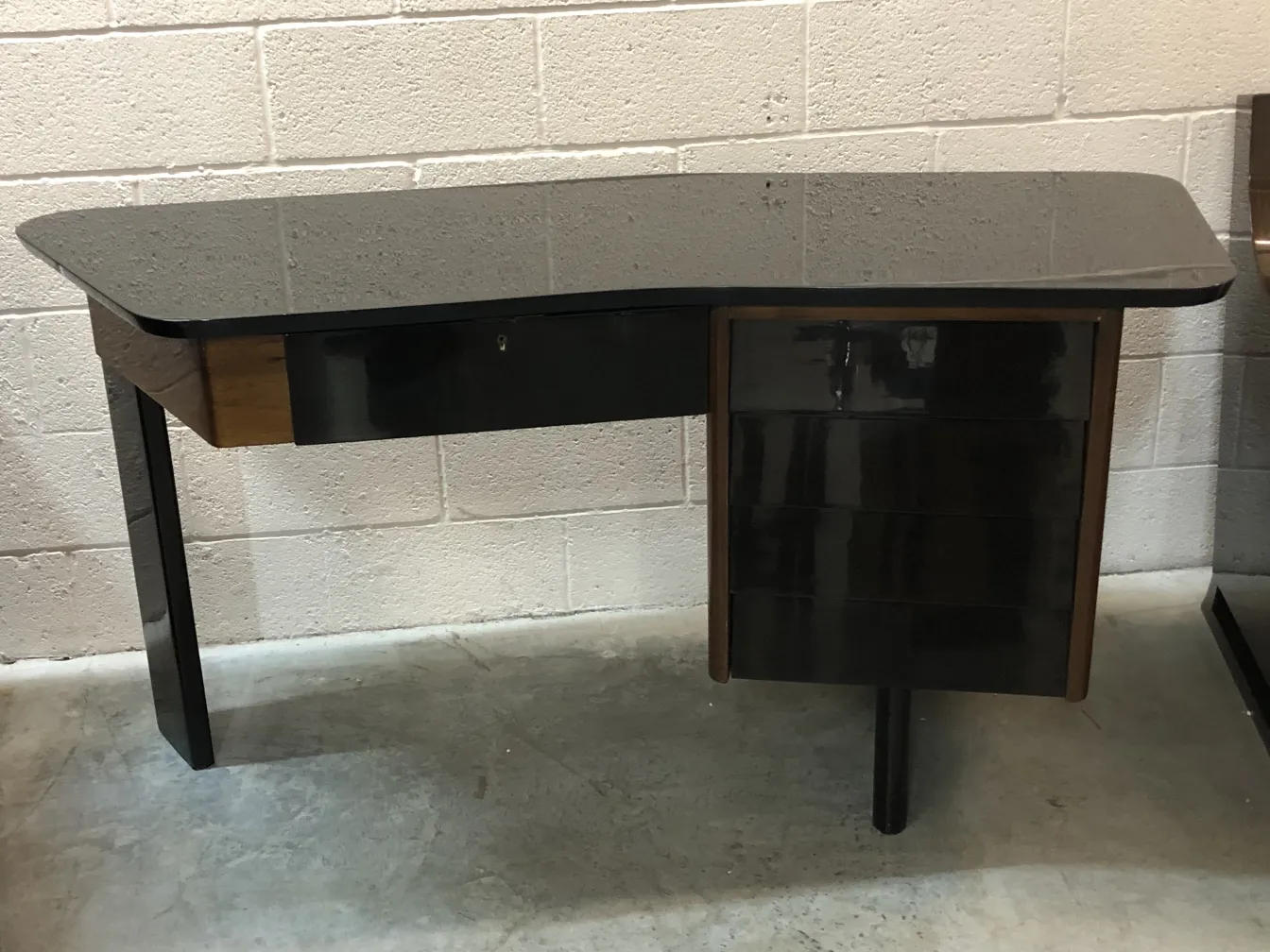 Escritorio antiguo con un acabado elegante y patas sólidas en un ambiente neutral