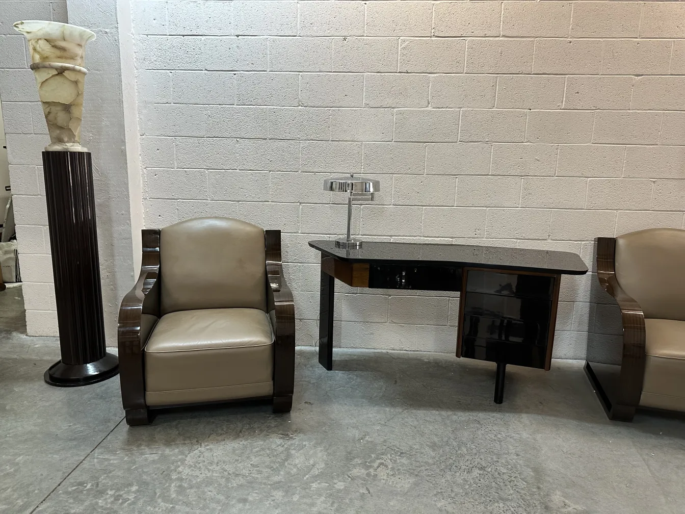 antique black desk next to light chairs in neutral setting