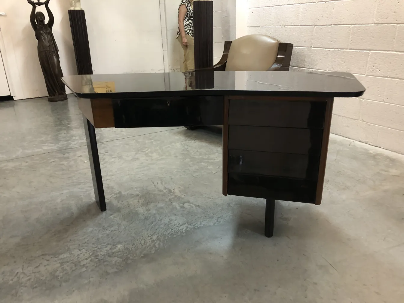 antik-schreibtisch-aus-holz-mit-eleganter-form-in-einer-antiquitaeten-umgebung-umgeben-von-skupturen