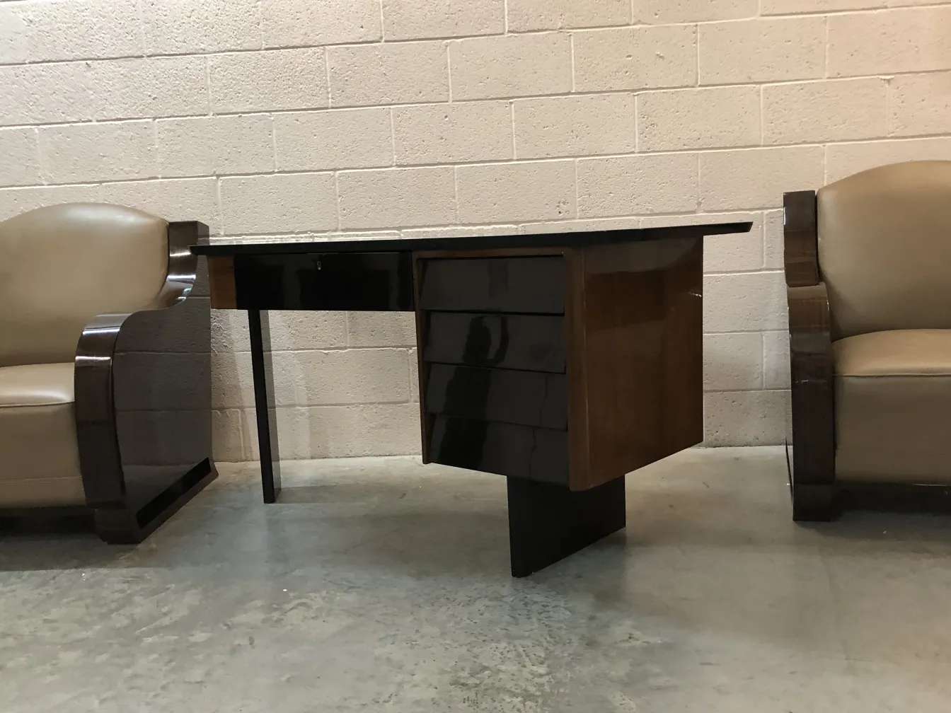 escritorio antigo com detalhes escuros e forma estilizada, cercado por cadeiras