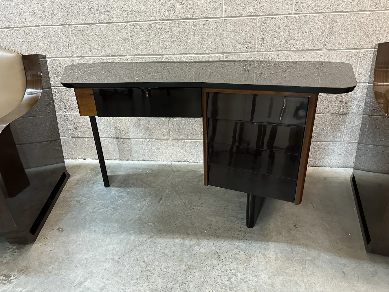 bureau ancien avec surface lisse et finitions sombres, entouré de chaises