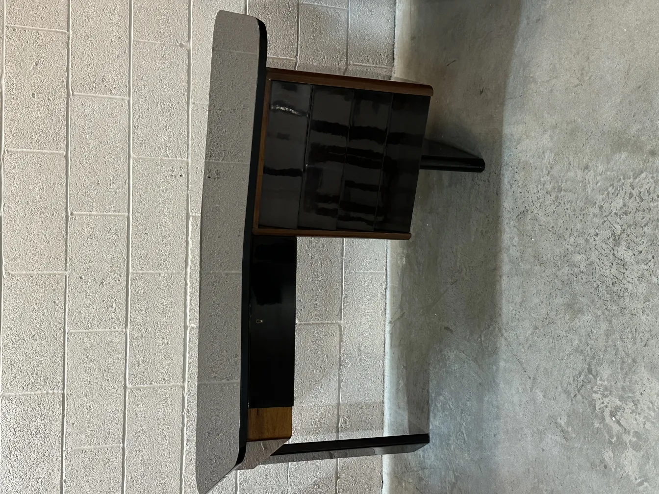 antique black desk with shiny surface in a minimalist setting