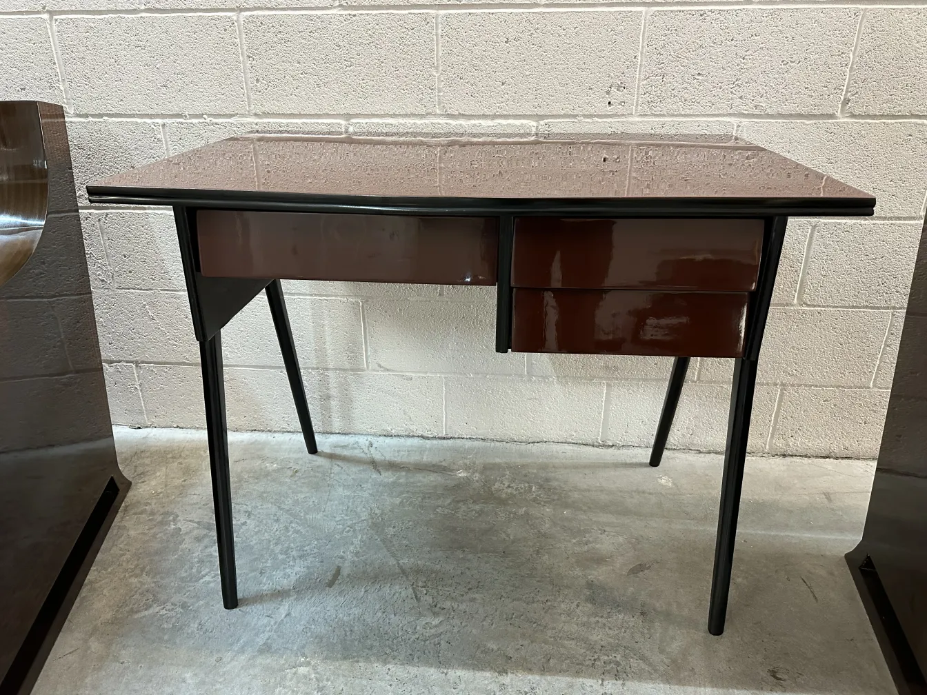 bureau antique avec deux tiroirs dans un environnement minimaliste.