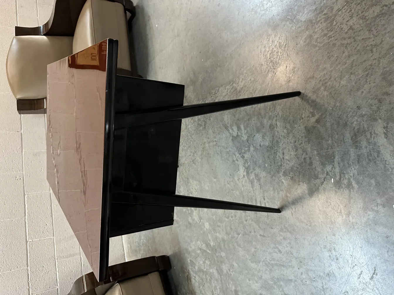 Antique desk with a smooth surface and slender legs, surrounded by a simple environment.