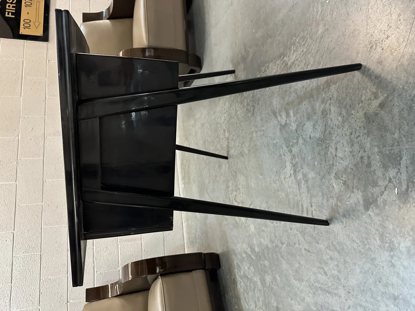 black antique desk with thin legs, gray background